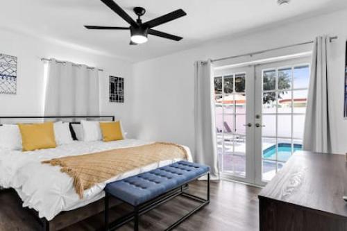 a bedroom with a bed and a ceiling fan at Serene Poolside Getaway in Miami Gardens