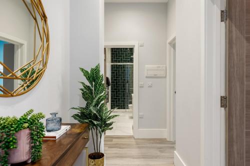 a hallway with a mirror and a table with plants at Tower House Apartments in Bournemouth