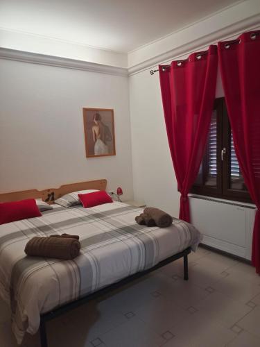 a bedroom with a large bed with red curtains at Le Sorgenti Guest House in Ilbono
