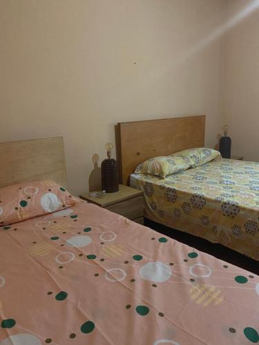a bedroom with two beds with flowers on them at La Rosa Buga in Buga