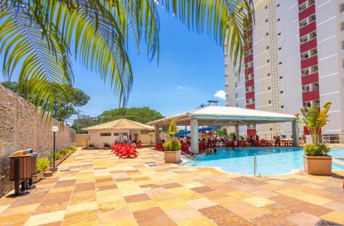 a pool at a hotel with a palm tree at VILLAS DIROMA RESIDENCE - BVTUR in Caldas Novas