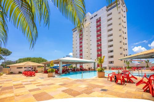 een zwembad met rode stoelen en een hotel bij VILLAS DIROMA RESIDENCE - BVTUR in Caldas Novas