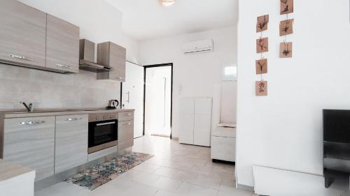 a kitchen with white cabinets and a tile floor at Leo's Villa in Milano Marittima