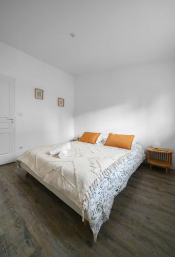 a bed in a room with a white wall at Résidence Epinat - Appartements centre & parking in Vichy