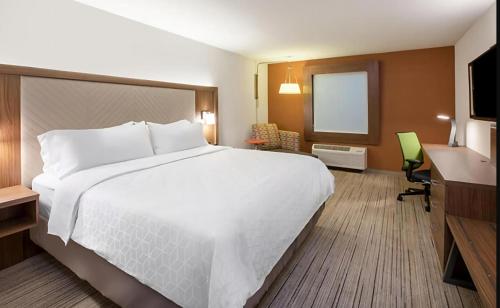 a hotel room with a large white bed and a desk at Holiday Inn Express - Minneapolis West - Plymouth by IHG in Plymouth