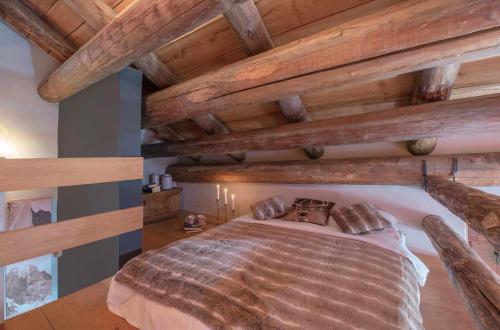 ein großes Bett in einem Zimmer mit Holzdecken in der Unterkunft La Stalla in Vicosoprano