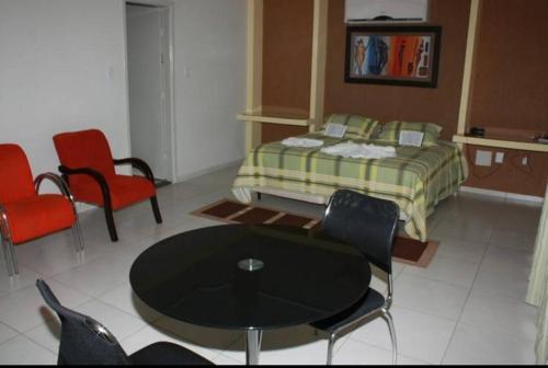 Zimmer mit einem Bett, einem Tisch und Stühlen in der Unterkunft Lagos Hotel in Catalão