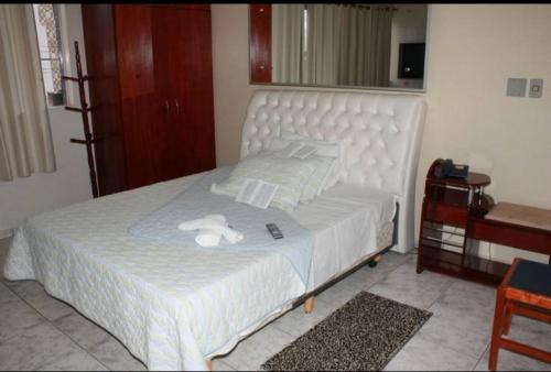 a bed with two white stuffed animals on it at Lagos Hotel in Catalão