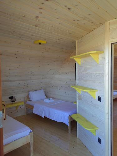 um quarto com 2 camas num chalé de madeira em Vikendica Nina 2 em Zlatibor