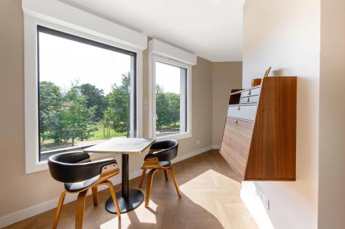 uma cozinha com mesa e cadeiras e uma janela em Appart Hôtel Coraline - Genas Lyon Eurexpo em Genas