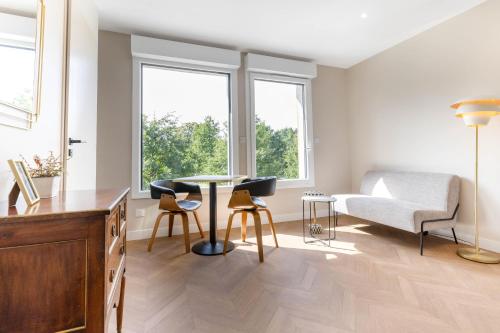 a living room with a table and chairs and a couch at Appart Hôtel Coraline - Genas Lyon Eurexpo in Genas