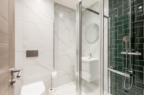 a bathroom with a shower with a toilet and a sink at Tower House Apartments in Bournemouth