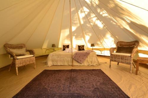 sypialnia w namiocie z łóżkiem i 2 krzesłami w obiekcie Casa Nova Estate w mieście Sitges