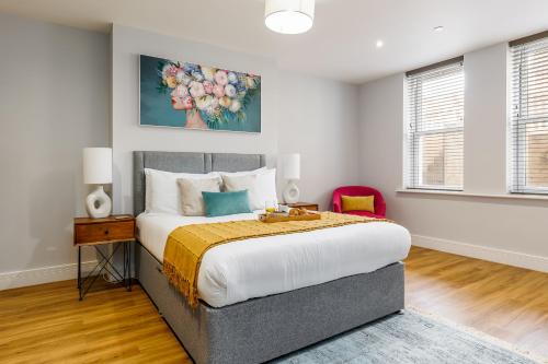 a bedroom with a bed and a painting on the wall at Tower House Apartments in Bournemouth