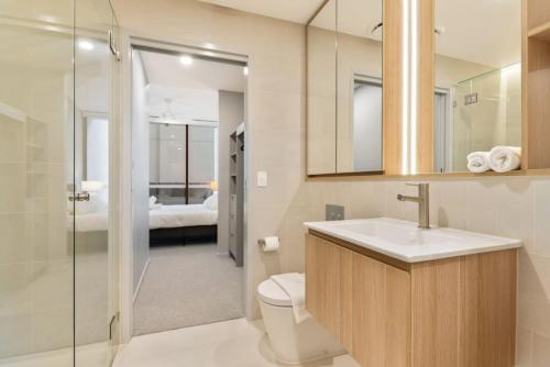 W łazience znajduje się toaleta, umywalka i prysznic. w obiekcie 1BR Luxury apt at prime location w carpark w mieście Brisbane
