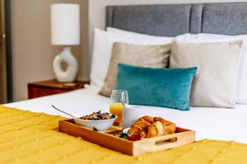 a tray of food on a bed with a plate of food at Tower House Apartments in Bournemouth