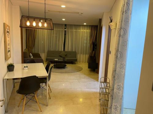 sala de estar con mesa, sillas y sofá en Vortex Suites Klcc By SALEH, en Kuala Lumpur
