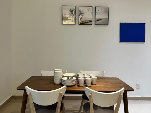 mesa de comedor con sillas blancas y mesa de madera en Modern Suite [12pax] @Farenheit 88 en Kuala Lumpur