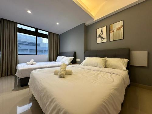 1 dormitorio con 2 camas y un osito de peluche en Modern Suite [12pax] @Farenheit 88 en Kuala Lumpur