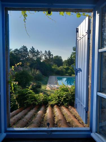 an open window with a view of a yard at Gite Les Volets Bleus du Segur in Le Ségur-Suech