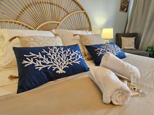 a bedroom with a bed with blue and white pillows at Brise Marine - Saint Gilles les Bains - Boucan - Studio vue mer in Saint-Gilles les Bains