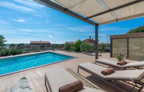 a patio with a swimming pool and two lounge chairs at Dianas Garden Design Villa in Umag