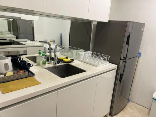 a kitchen with a sink and a refrigerator at Vortex Suites Klcc By SALEH in Kuala Lumpur