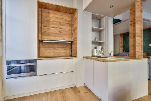 une cuisine avec des armoires blanches et un évier dans l'établissement Lovely apartment central Bordeaux, à Bordeaux