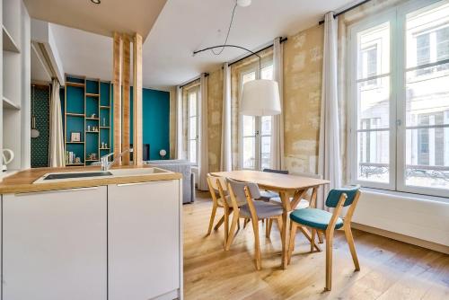une cuisine avec une table et des chaises en bois dans l'établissement Lovely apartment central Bordeaux, à Bordeaux