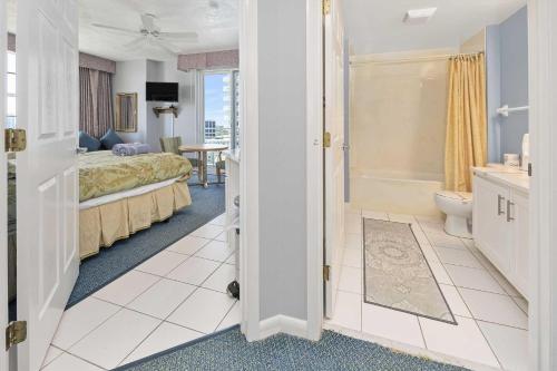 a bedroom with a bed and a bathroom at Luxury 12th Floor 2 BR Condo Direct Oceanfront Wyndham Ocean Walk Resort Daytona Beach | 1201 in Daytona Beach