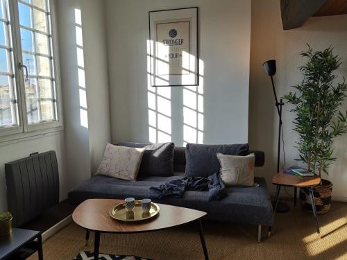 un soggiorno con divano blu e tavolo di Lovely apartment dowtown a Bordeaux