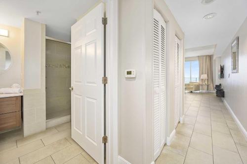 pasillo con puerta blanca y baño en Luxury 9th Floor 1 BR Condo Direct Oceanfront Wyndham Ocean Walk Resort Daytona Beach | 908, en Daytona Beach