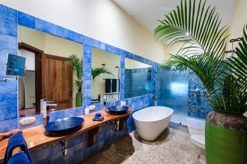 y baño con azulejos azules, bañera y lavamanos. en Boutique Hotel Luna Azul, en Ostional