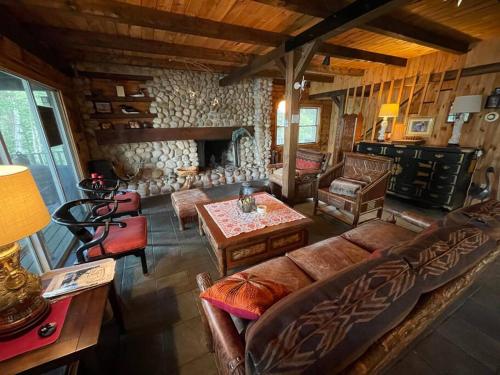 een woonkamer met een bank en een open haard bij Spectacular Seven Keys Camp on Pristine Loon Lake 