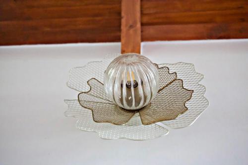 a glass flower ornament hanging from a ceiling at Little Things Earth - Pine villa in Auroville