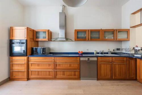 una grande cucina con armadi in legno ed elettrodomestici di Family house Bordeaux a Bordeaux