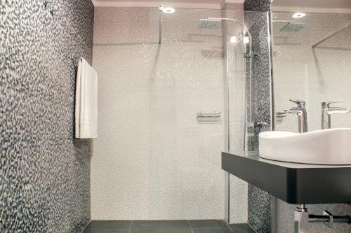 a bathroom with a sink and a glass shower at Santa Cruz Apartments in Málaga