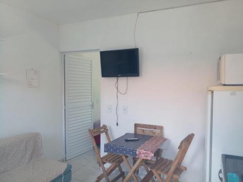 a room with a table and chairs and a television on the wall at Apartamentos PRAIA DE BOMBAS in Bombinhas