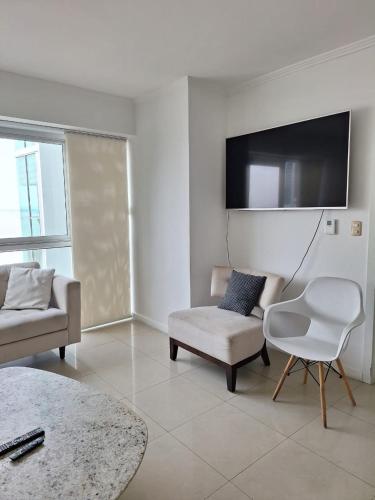 a living room with a couch and a chair and a tv at Room with a view in Guayaquil
