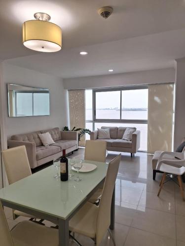 a living room with a table with a bottle of wine at Room with a view in Guayaquil