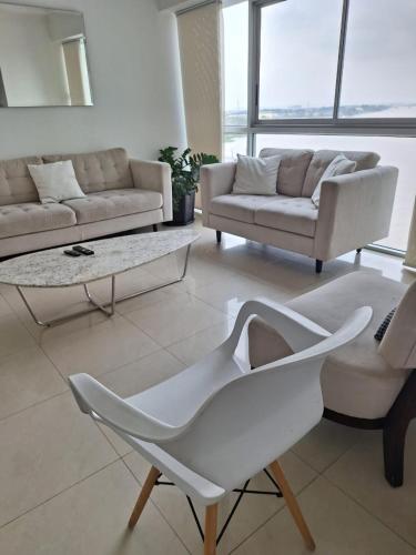 a living room with a white couch and a table at Room with a view in Guayaquil