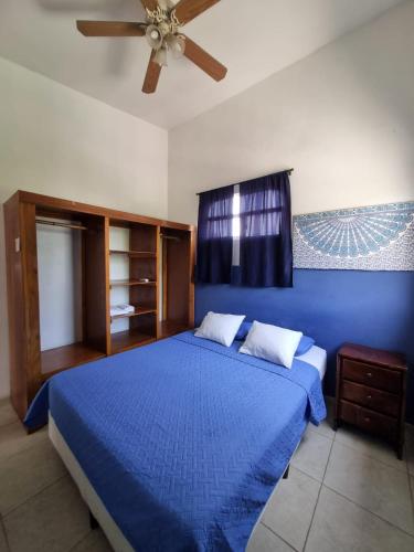 a bedroom with a blue bed with a ceiling fan at Mini Apartamento Giada in Nicoya