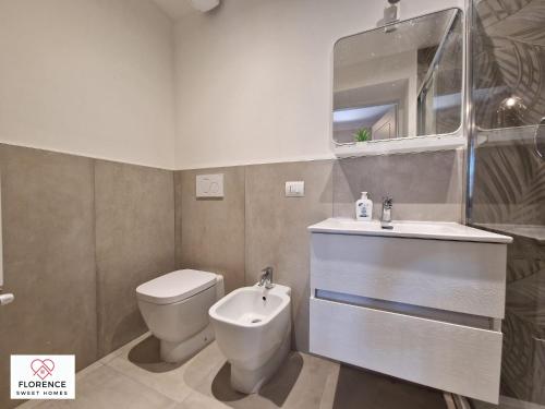 een badkamer met een toilet, een wastafel en een spiegel bij Lella Apartment with free parking in Florence