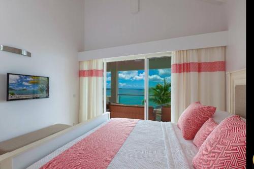 a bedroom with a bed with a view of the ocean at Seafront sunset & beach access in Saint Martin