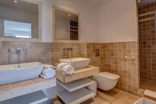 a bathroom with a tub and a sink and a toilet at Seafront sunset & beach access in Saint Martin
