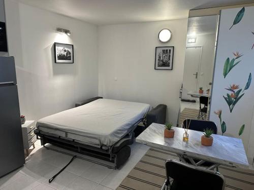 una camera ospedaliera con un letto e un tavolo di Studio indépendant proche Paris a Chennevières-sur-Marne