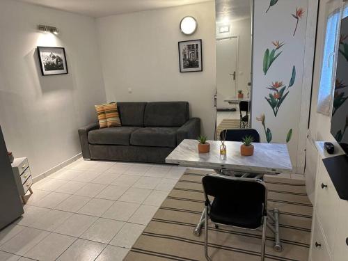 un soggiorno con divano e tavolo di Studio indépendant proche Paris a Chennevières-sur-Marne
