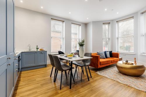 a kitchen and living room with a table and chairs at Tower House Apartments in Bournemouth