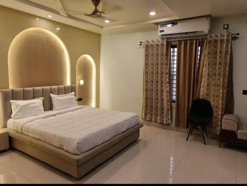 ein Schlafzimmer mit einem großen Bett und einem Stuhl in der Unterkunft Hotel Ganesh Inn By BookingCare in Rewa