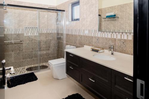 a bathroom with a sink and a glass shower at The Paradise Vista Ocho Rios in Ocho Rios